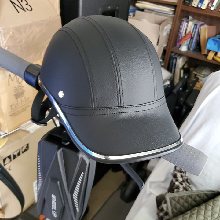 A reviewer's helmet sitting on the handlebars of their scooter