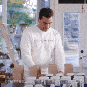 gif of david from schitt&#x27;s creek organizing inventory on a table