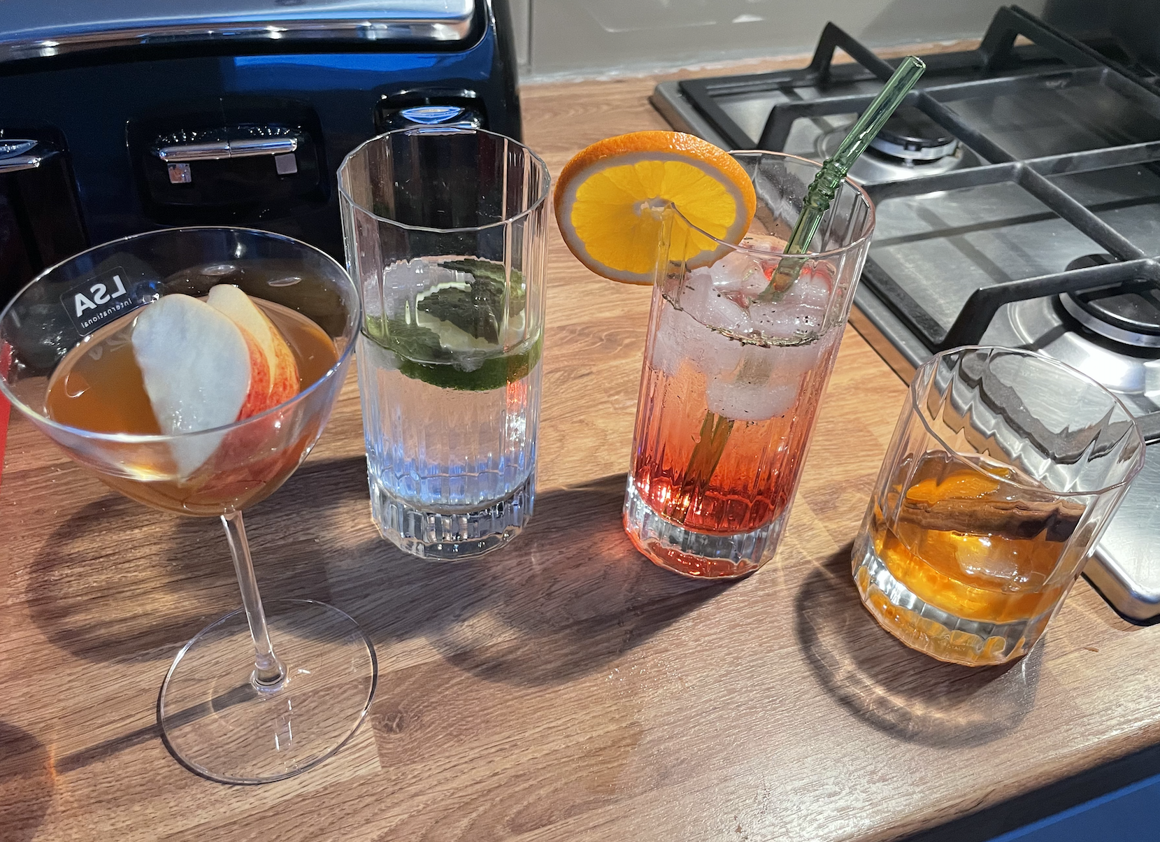 the four completed cocktails sitting on a kitchen counter