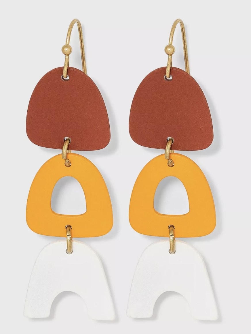 a pair of rust, orange, and white acrylic drop earrings
