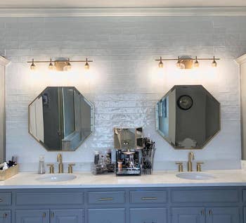 reviewer photo of two gold mirrors hanging over double sinks in a bathroom