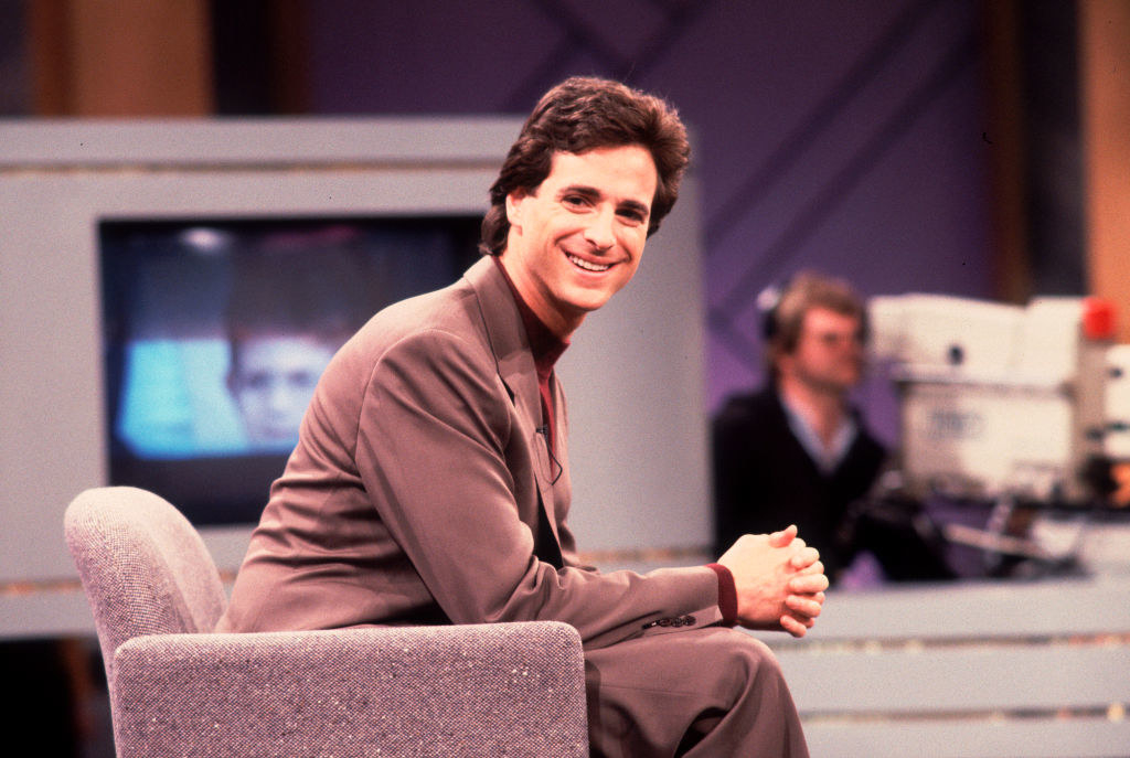 A young Bob sitting in a chair on a TV studio set and smiling at the camera