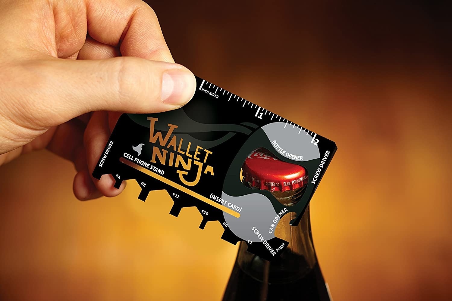 Hand uses black 18-in-1 multi-purpose pocket tool to open beer bottle