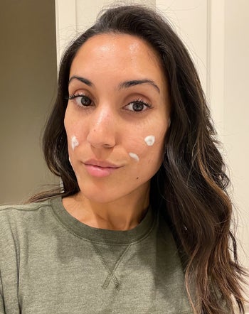 Jasmin using the face wash as a spot treatment with dots of the cleanser on her cheeks