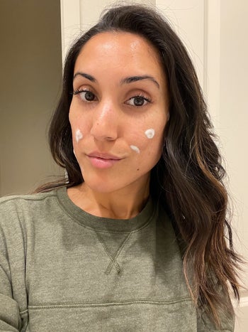 Jasmin using the face wash as a spot treatment with dots of the cleanser on her cheeks