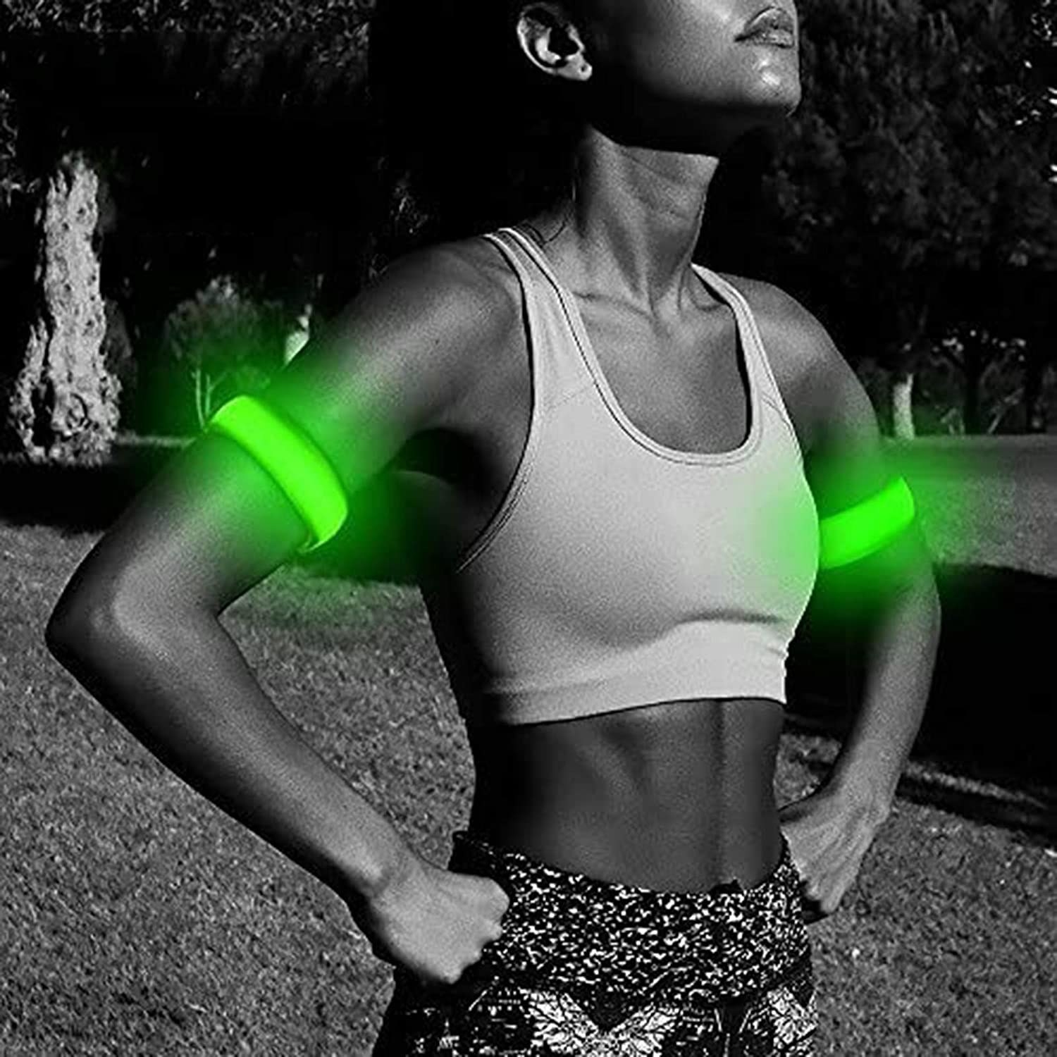 model running at nighttime with green LED arm bands on their arms