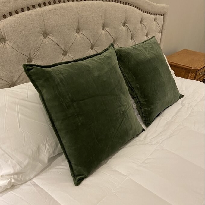 Two green pillow cases on a bed