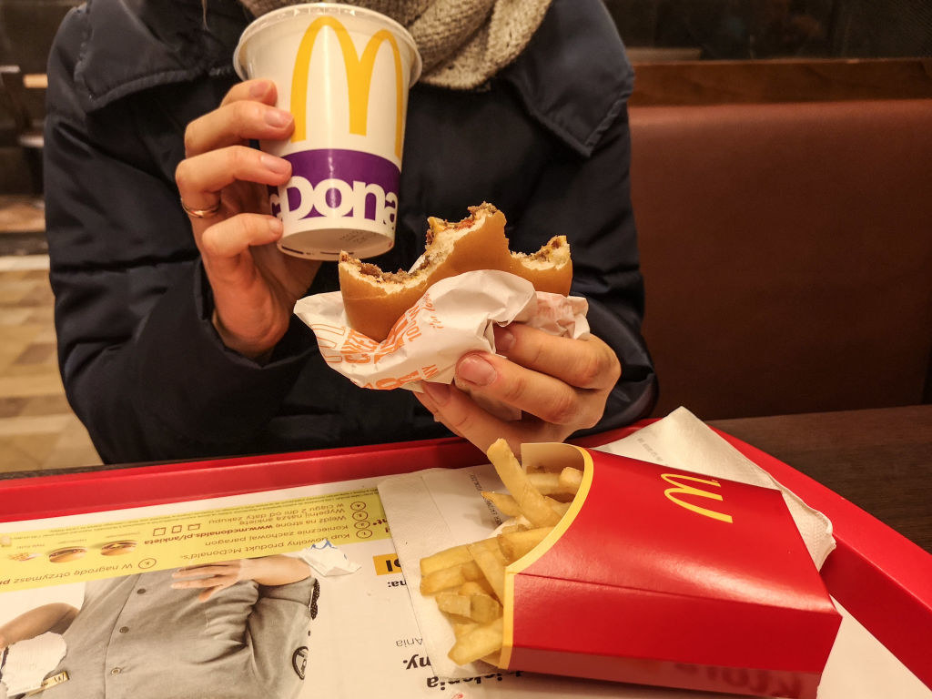 A person eating McDonald&#x27;s burger and fries.