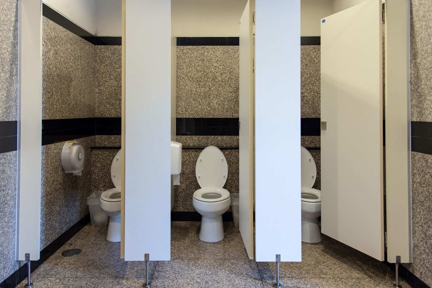 A public restroom with bathroom stalls.