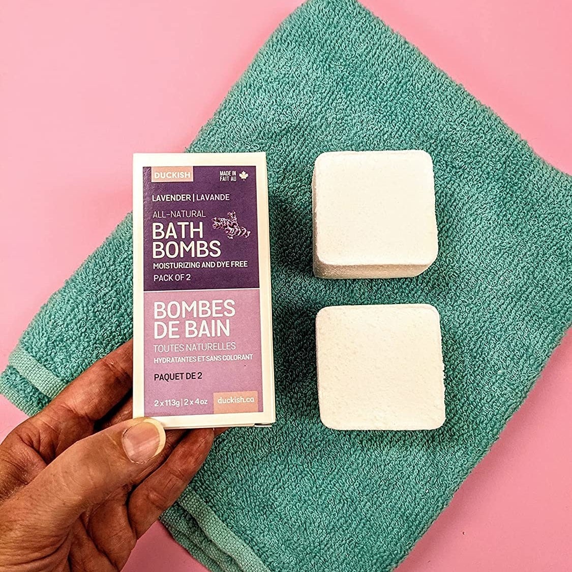 a pair of cube-shaped bath bombs on a colourful towel