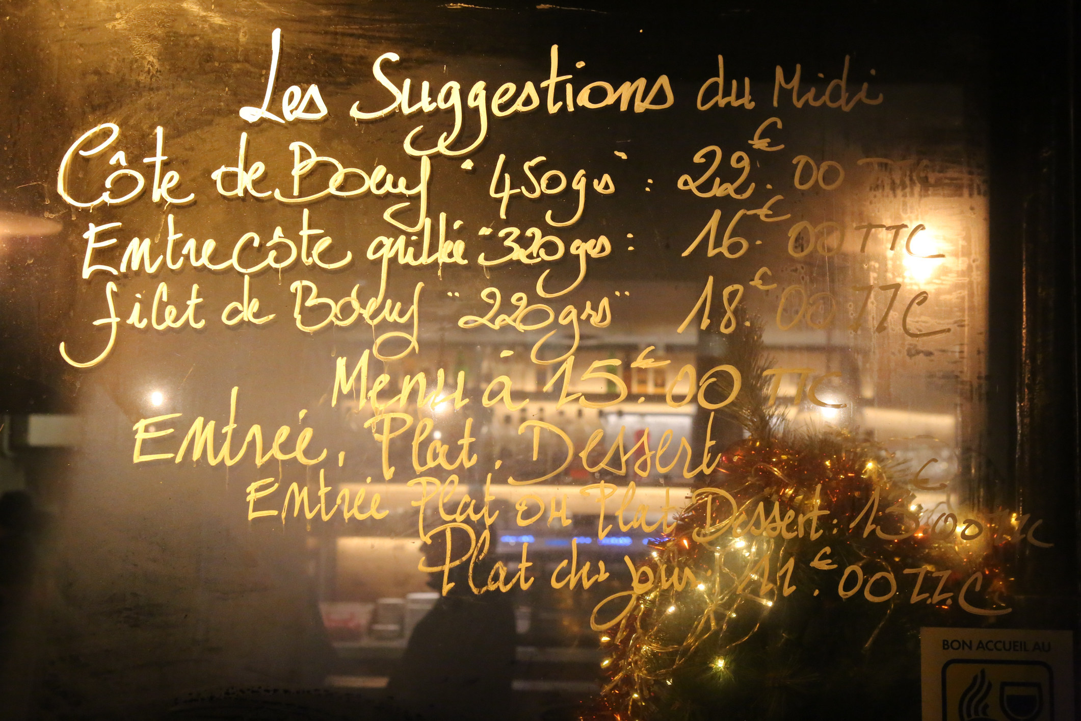 A French menu written on a board.