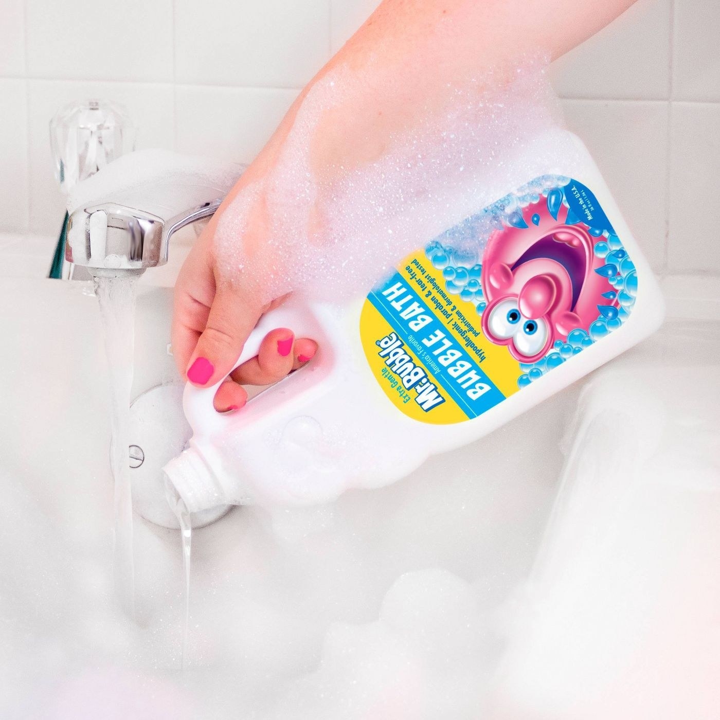 Hand pouring a bottle of Mr. Bubbles into a tub
