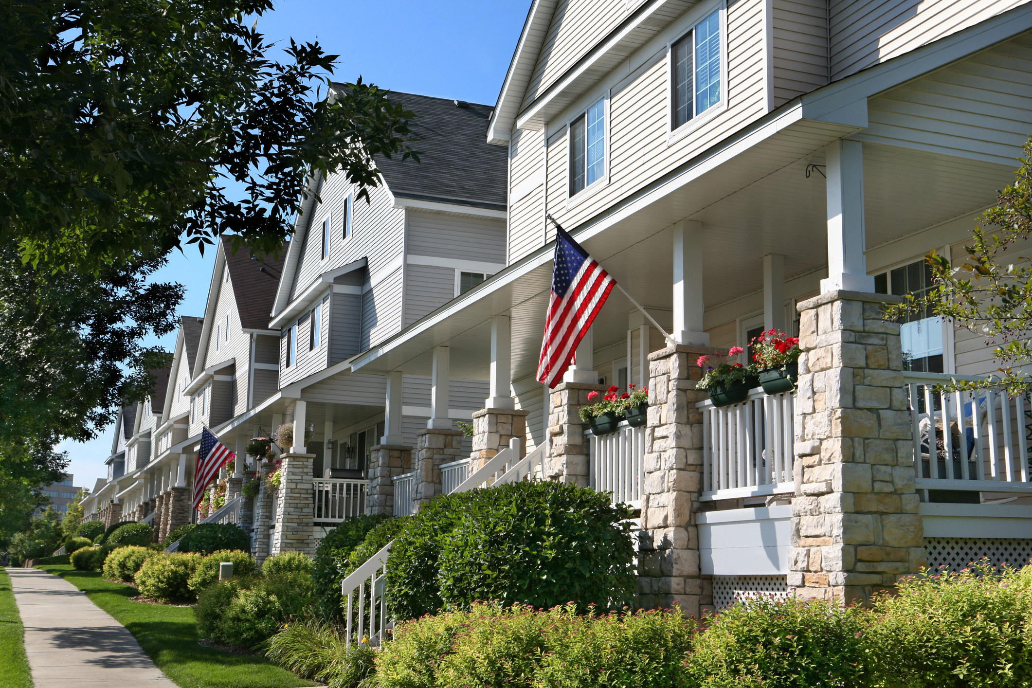 A row of townhouses with American flags flying.