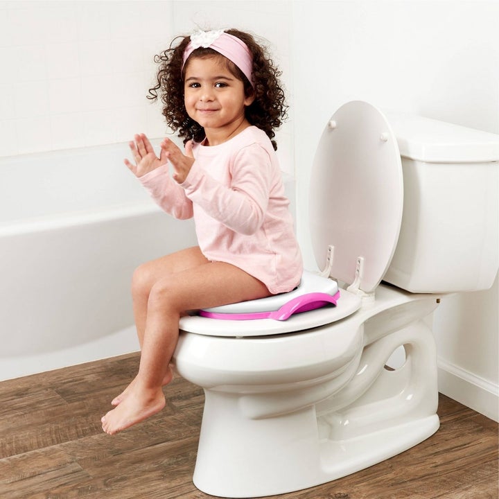 Child sitting on Peppa Pig soft seat on toilet