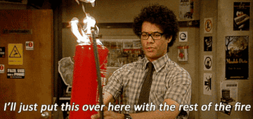 Moss holding a flaming fire extinguisher in &quot;The IT Crowd&quot;