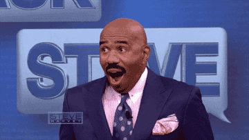 Steve Harvey opens his mouth in shock like he's just heard some juicy news