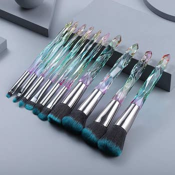 the makeup brushes that have a teal tip and a crystal iridescent handle