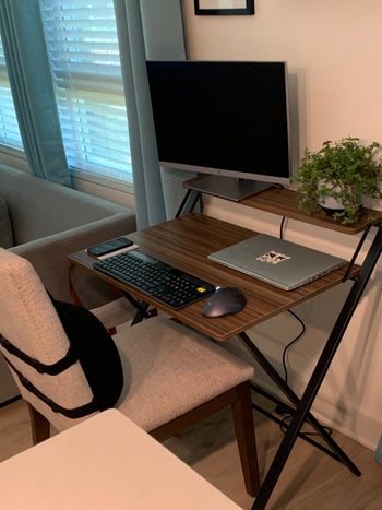 The woodgrain and black desk with a keyboard/laptop/mouse level and a smaller higher level for display items or monitors