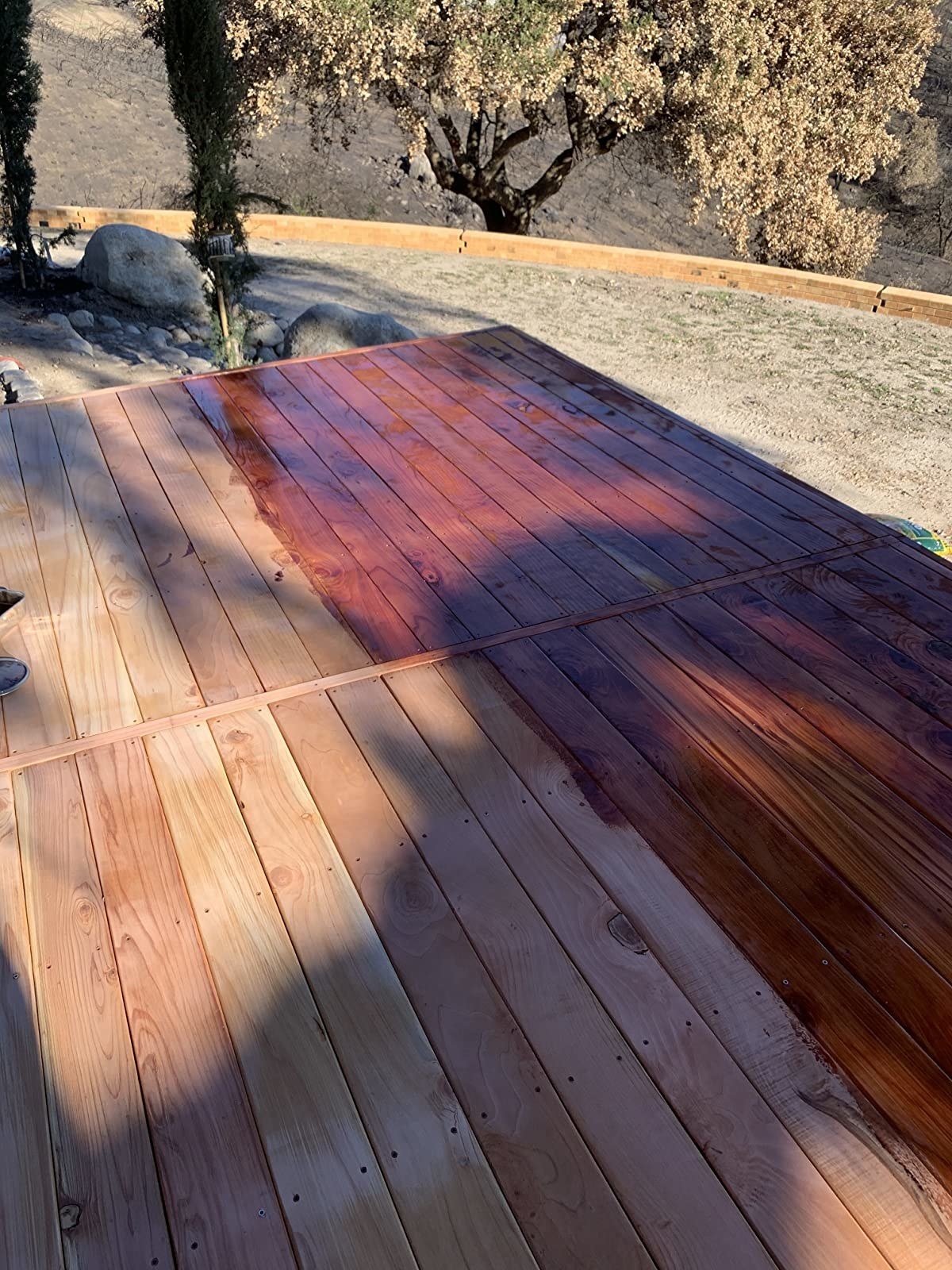 reviewer image of deck half stained, with the half-stained side vibrant and bright