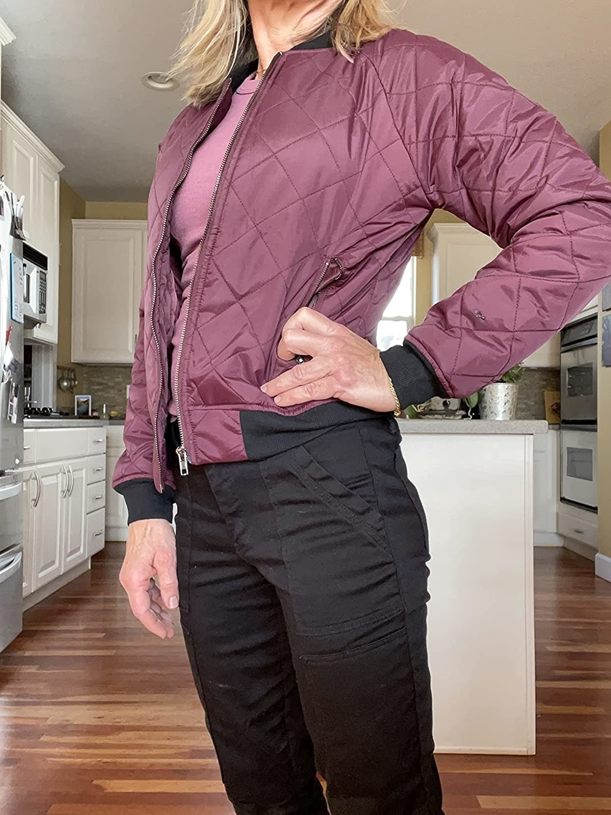 Reviewer wearing pink and black bomber quilted jacket with black pants