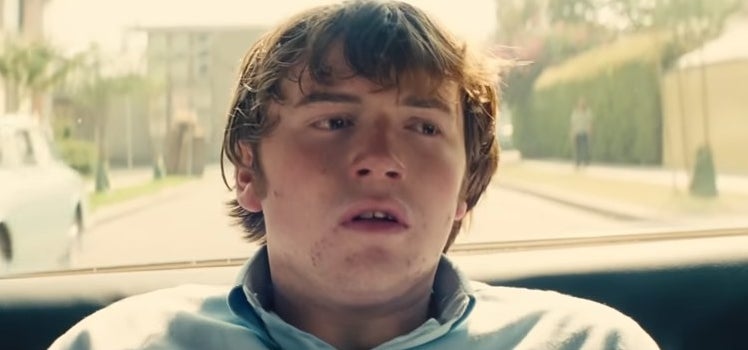 Gary looking worried as he sits in a police car in "Licorice Pizza"