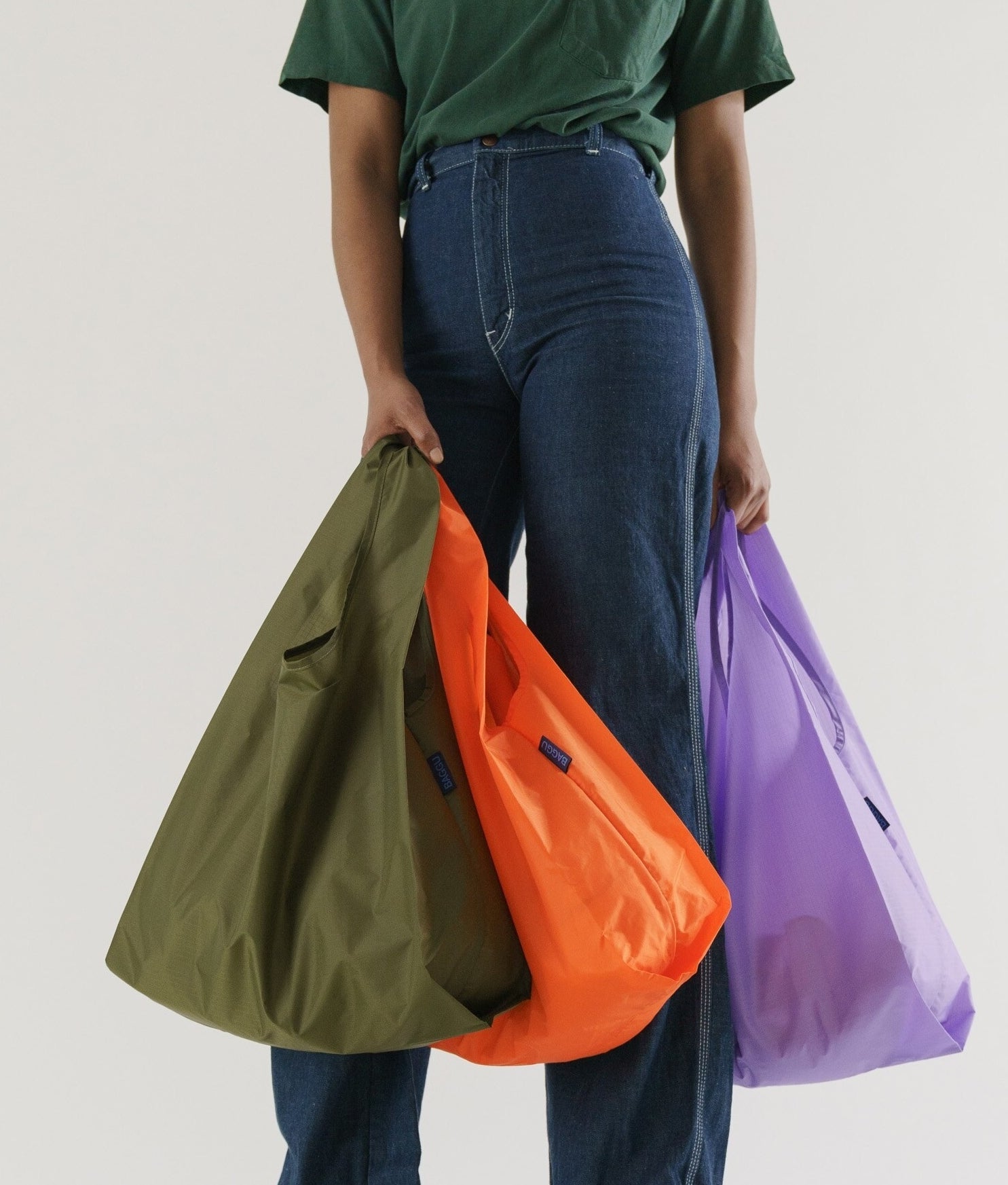 A person carrying three large bags