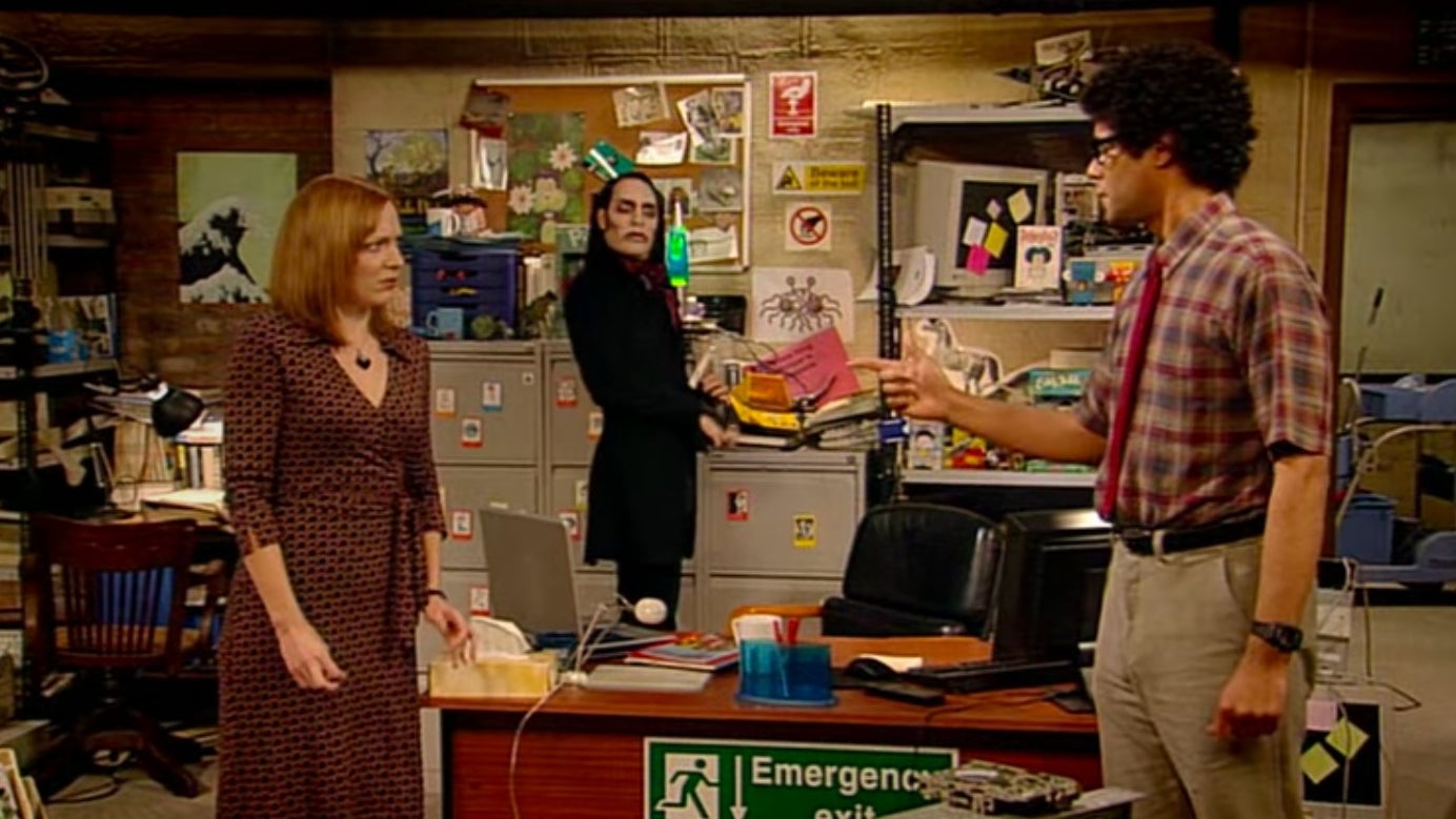 Moss pointing at Jen with Richmond standing in the background, staring at Moss, in &quot;The IT Crowd&quot;