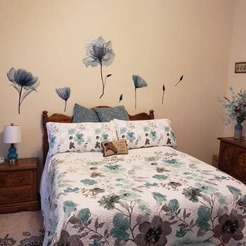 the blue flowers on a wall above someone's bed