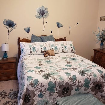 the blue flowers on a wall above someone's bed
