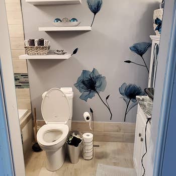 reviewer photo of the blue flowers on the wall of their bathroom