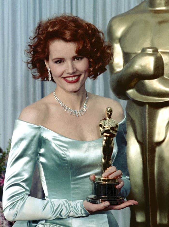 Geena smiles and holds her Oscar