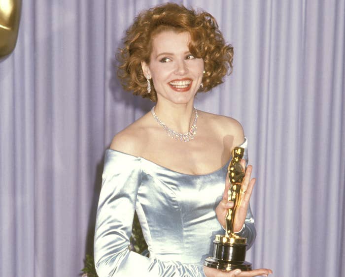 Geena smiles and holds her Oscar