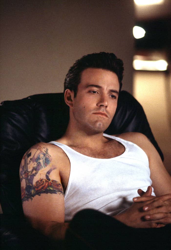 Affleck sits on a couch while wearing a tank top