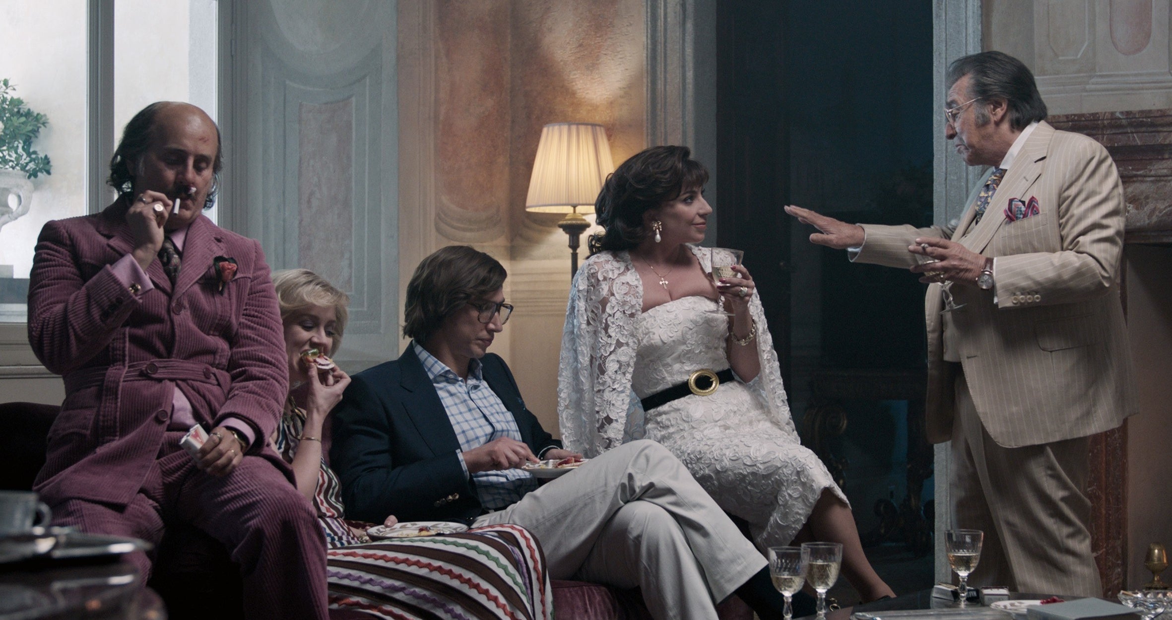 The Gucci family sits on a couch together in the film