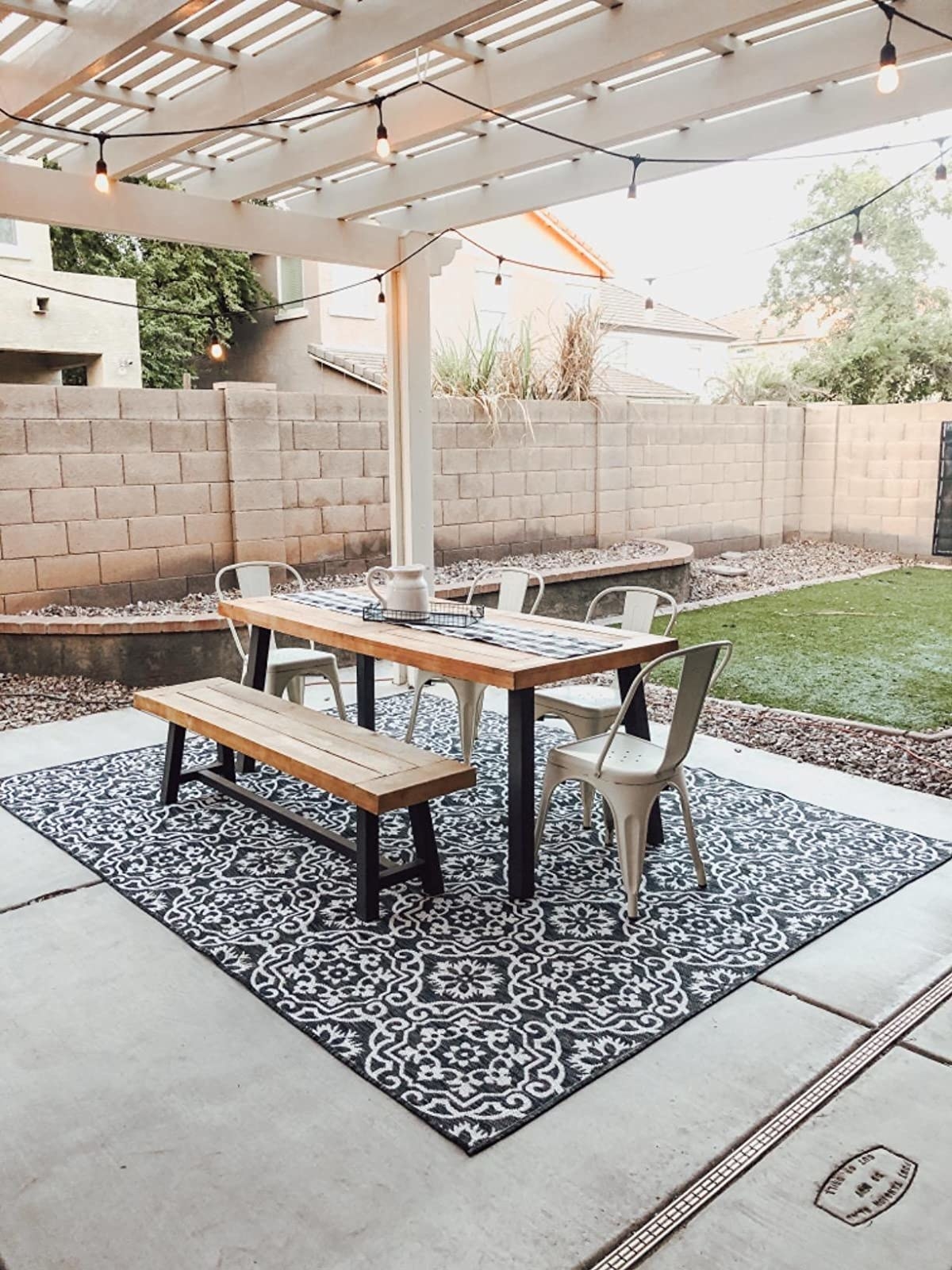 reviewer image of patio rug styled under outside dining table