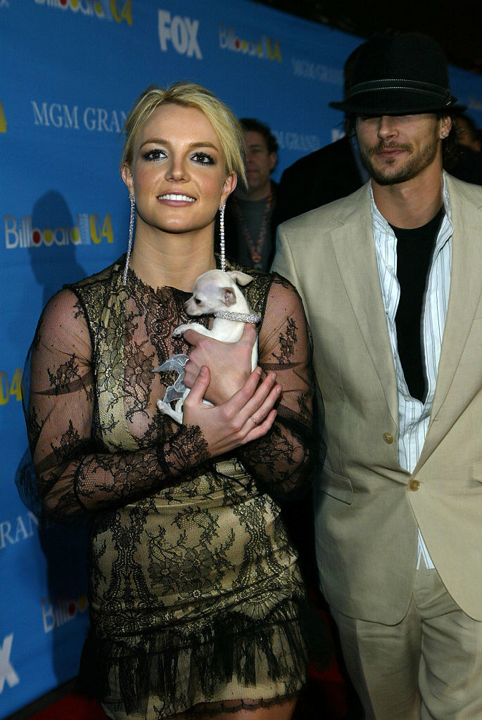 Britney is walking the red carpet with a small dog and Kevin Federline