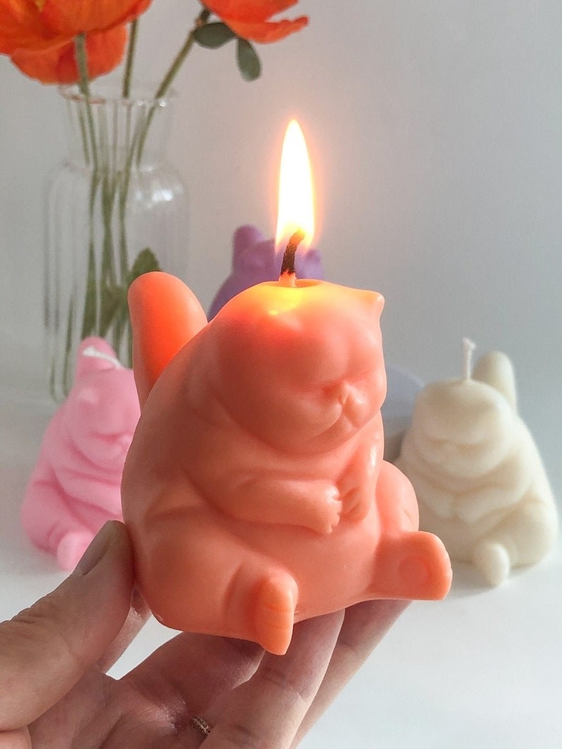model holding the orange grumpy cat candle