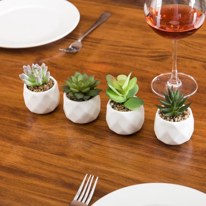 The four potted artificial succulents on a table