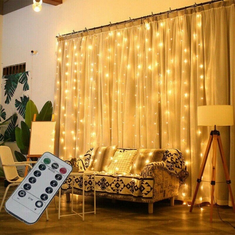 The gold curtain lights on sheer curtains in a living room, with remote control to access all eight settings and adjust dimmness