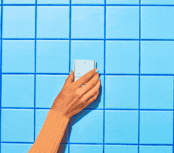 a gif of the dispenser being installed on a tile wall with Command Strips