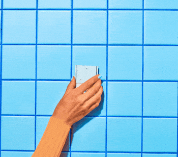 a gif of the dispenser being installed on a tile wall with Command Strips