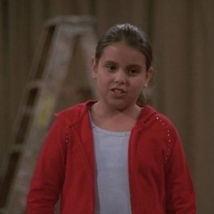 A young Beanie Feldstein with a ponytail in her hair in a red hoodie