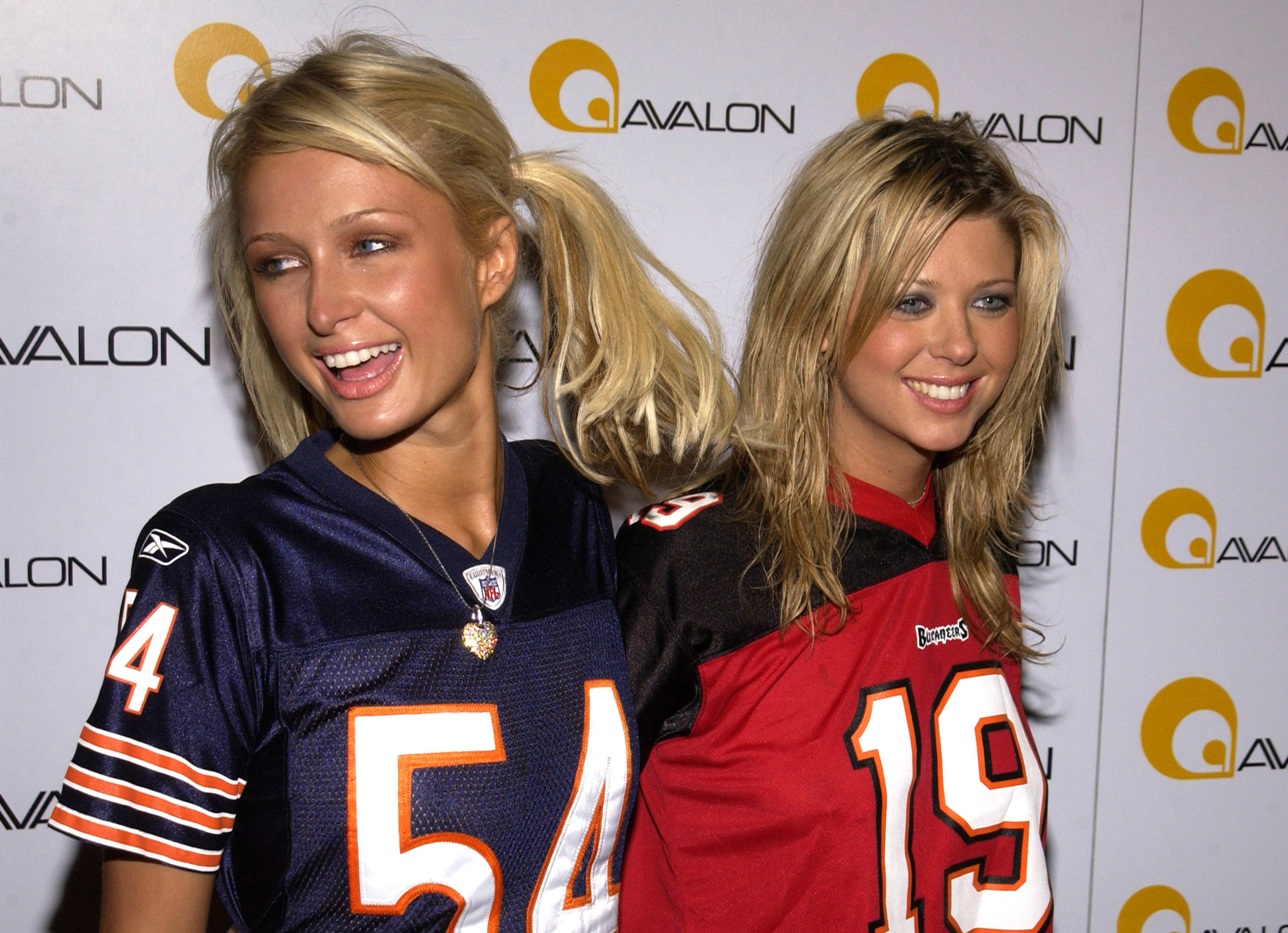 Paris Hilton and Tara Reid in football jerseys in front of a background that reads &quot;avalon&quot;