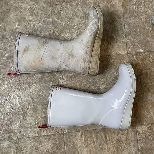 one muddy and stained rainboot and another white and clean