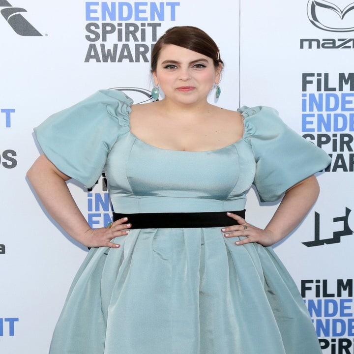 Beanie Feldstein wears a satin blue dress