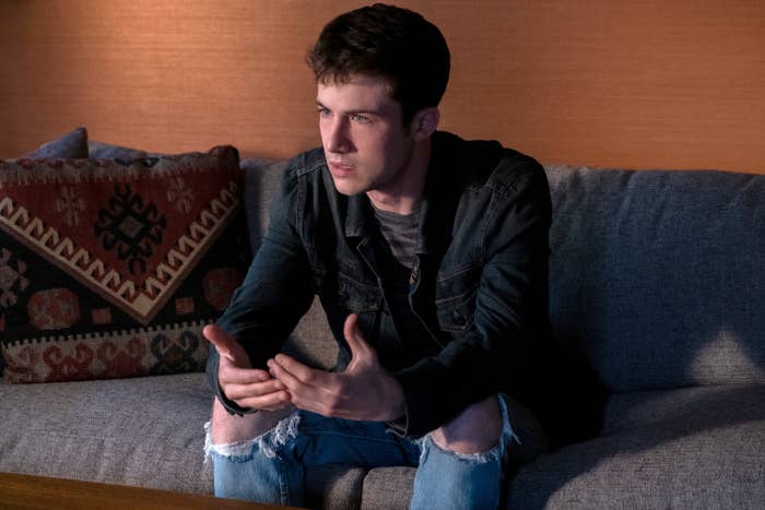 Clay sitting on a couch and leaning forward