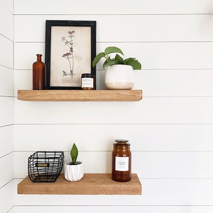 A reviewer&#x27;s photo of the natural wood shelves in her bathroom