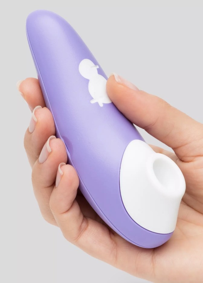A model holding a purple clit stimulating vibrator