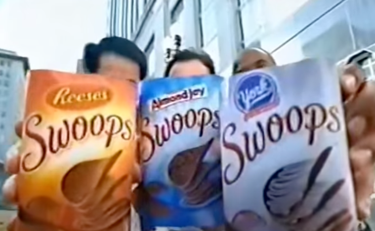 Three people in a TV ad holding up three varieties of Swoops flavors to the camera