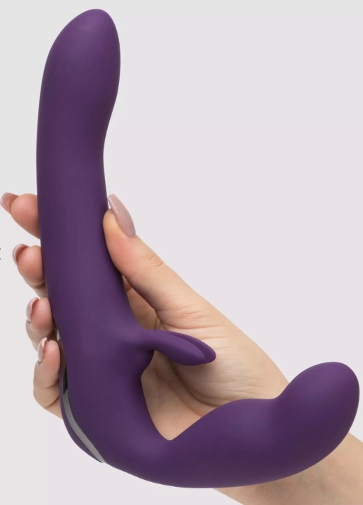A model holding a purple strapless strap-on